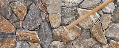 A stone wall with a wooden stick